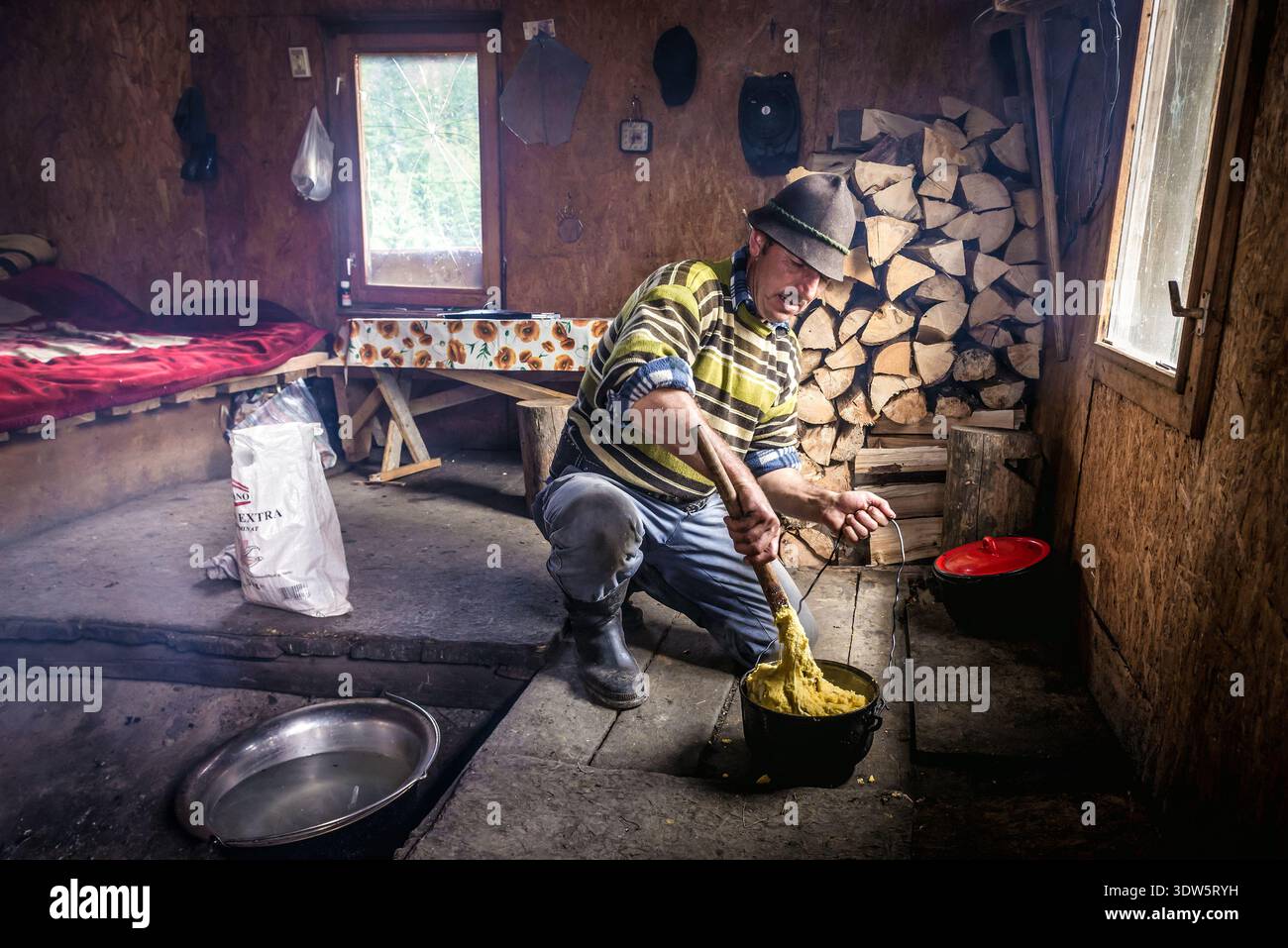 Borsa, Romania - 12 luglio 2019: Pastore cucina tradizionale rumeno mamaliga in capanna sui monti Rodna Foto Stock