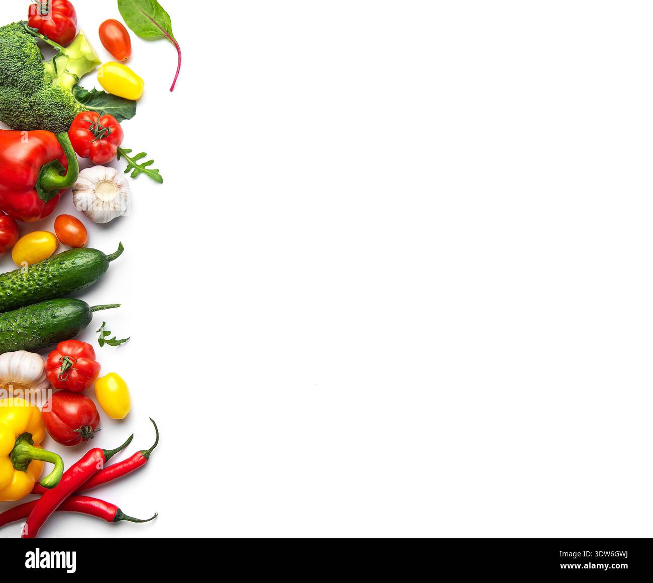 Verdure appena raccolte, tra cui peperoni, cetrioli e pomodori su sfondo bianco Foto Stock