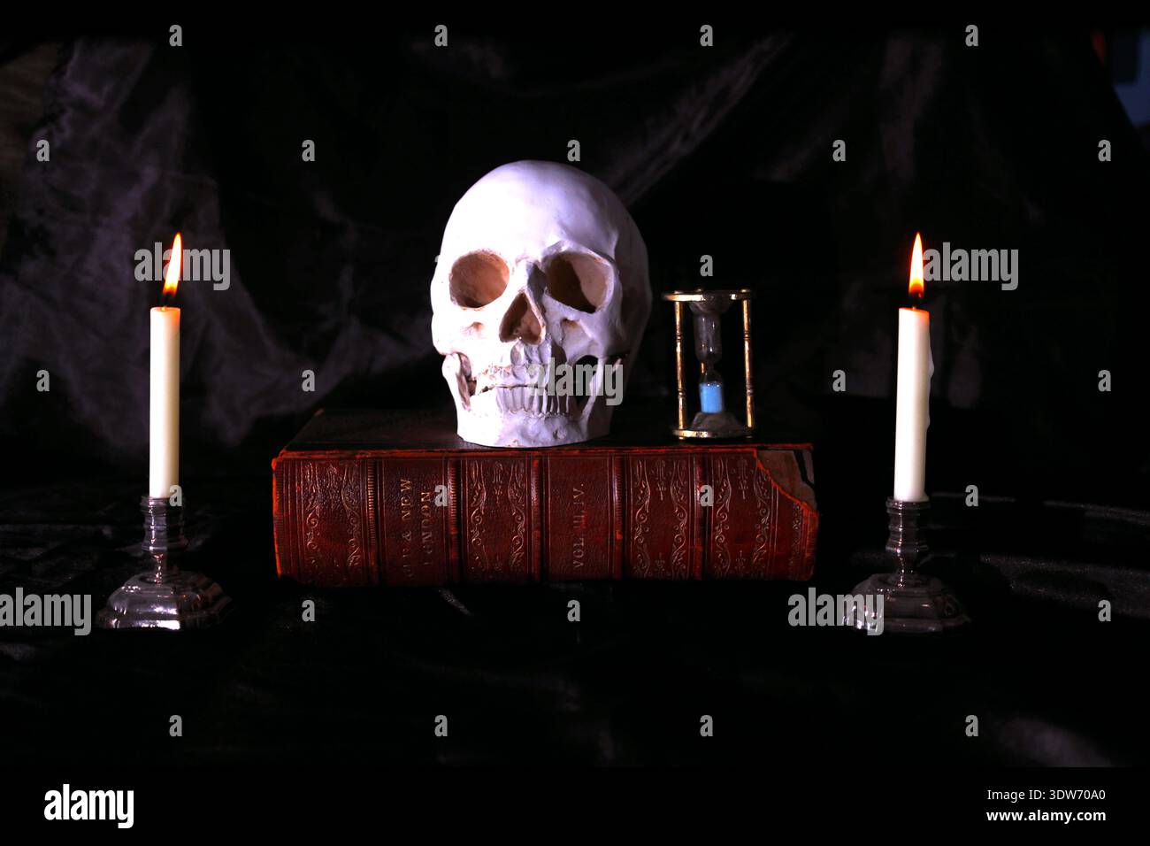 Teschio umano e candele ancora in vita. Foto Stock