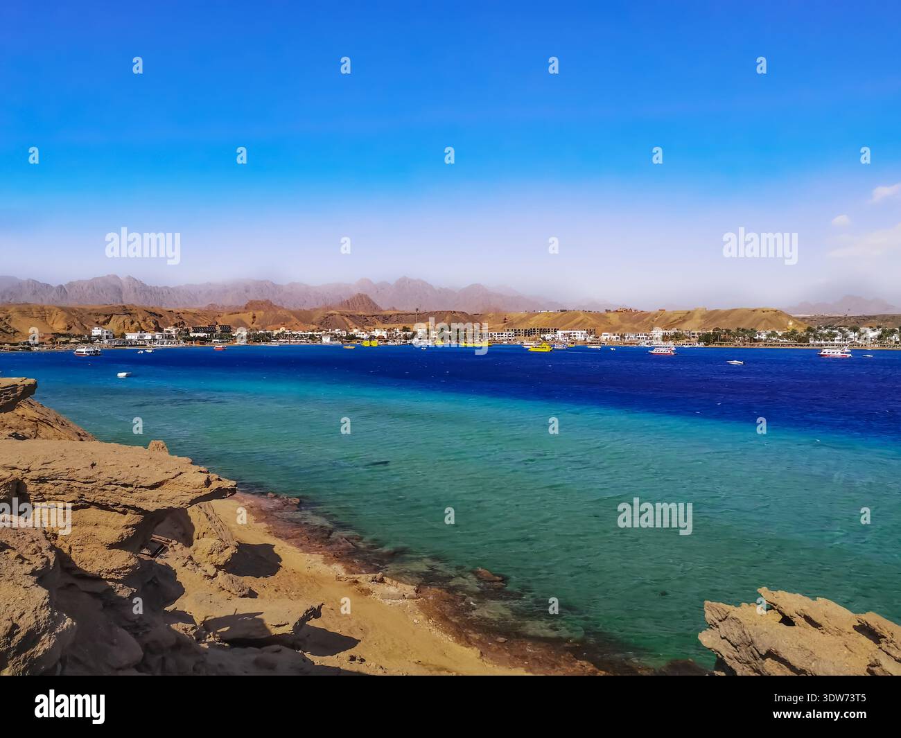 Spiaggia selvaggia nella baia di Sharm El-Maya a Sharm El Sheikh (Egitto). Splendido panorama sul mare con acque turchesi e azzurre e le montagne del Sinai Foto Stock