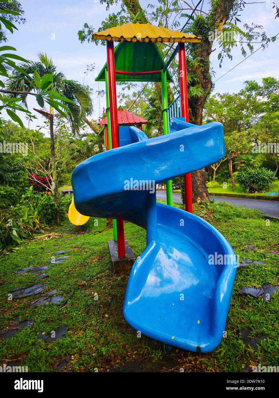 Un colorato scivolo a spirale in un parco giochi naturale per bambini Foto Stock