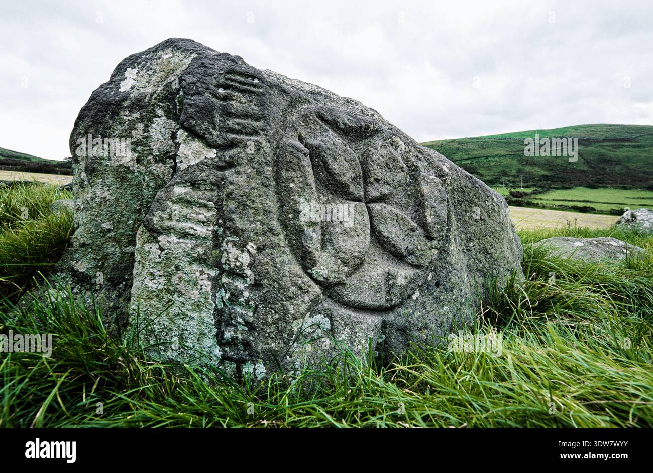 Sito del monastero medievale di Kilcolman. Dingle, Kerry, Irlanda. La croce celtica cristiana e la scrittura Ogham incisero la pietra. Croce, patty Foto Stock