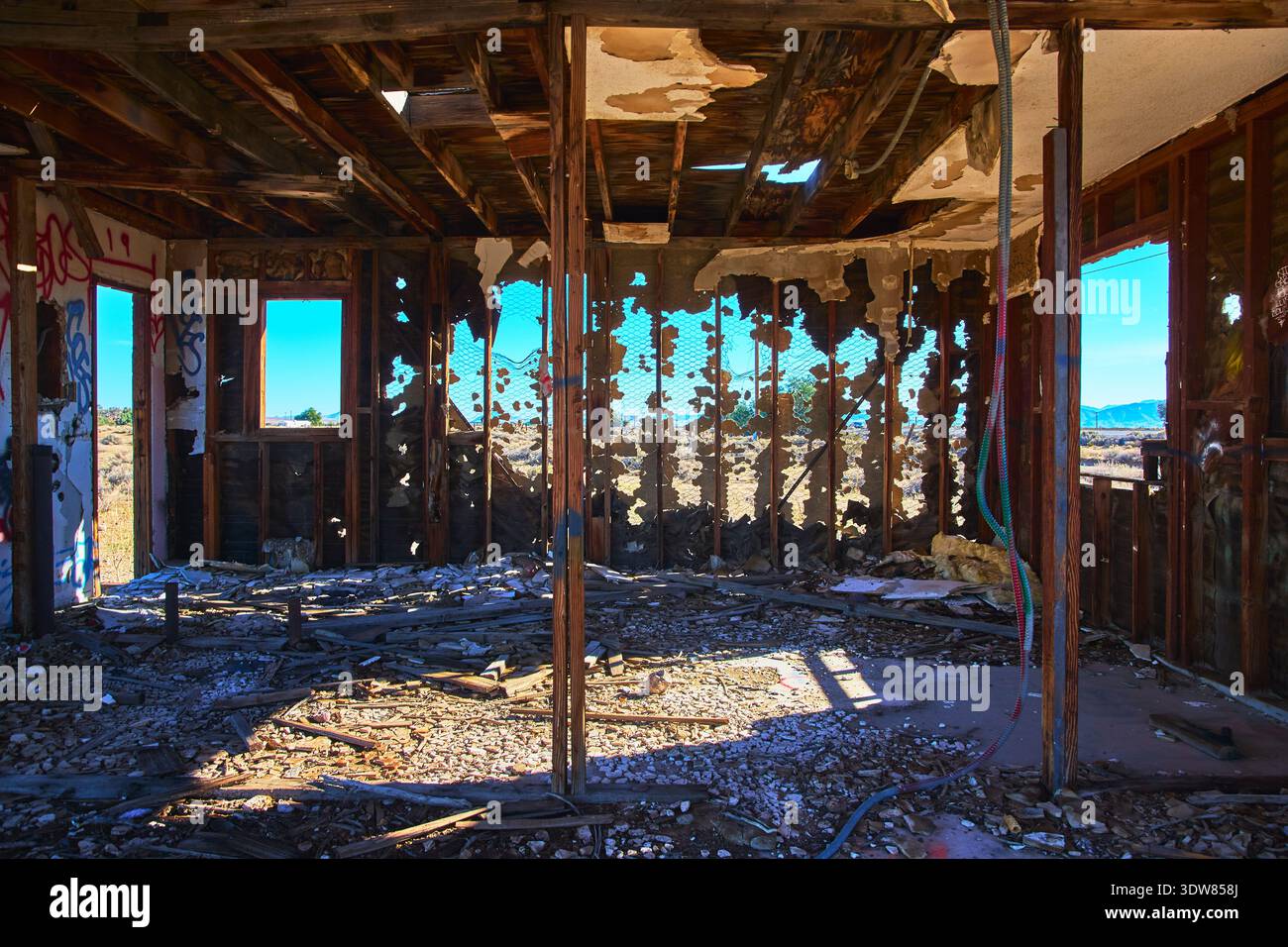 Interno abbandonato della casa nel deserto con graffiti e luce del sole nelle rovine Foto Stock