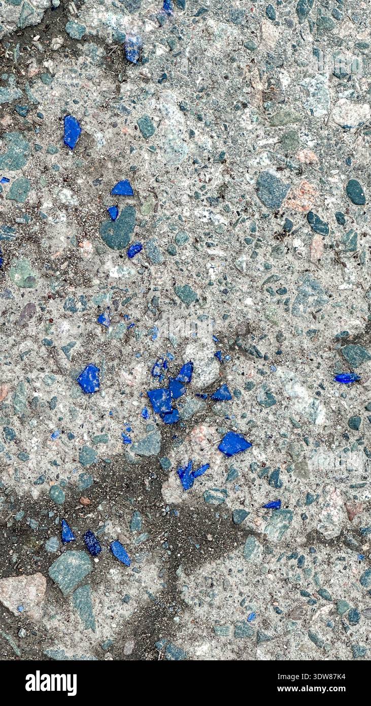 Vetro blu rotto sul cemento. Il vetro è frantumato e sparso per terra. Foto Stock