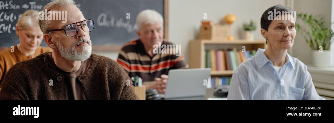 Intestazione di Senior Caucasian Man and Woman Listening in Adult Learning Session Foto Stock