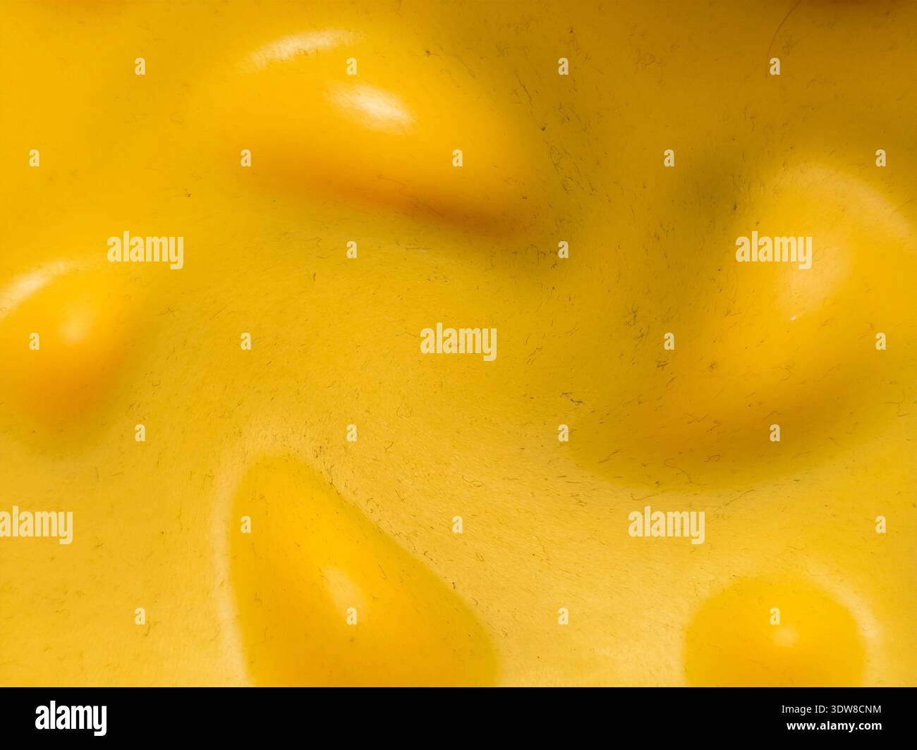 Primo piano di una superficie ruvida gialla con dossi arrotondati e ombre morbide. Sfondo astratto con forme organiche e materi in plastica o gomma lisci Foto Stock
