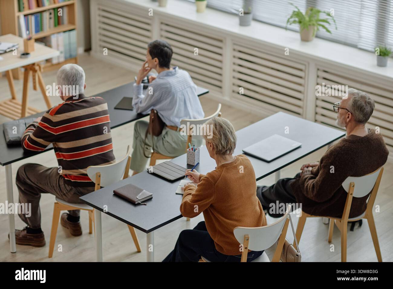 Gruppo di adulti caucasici anziani che partecipano a una lezione educativa in aula Foto Stock