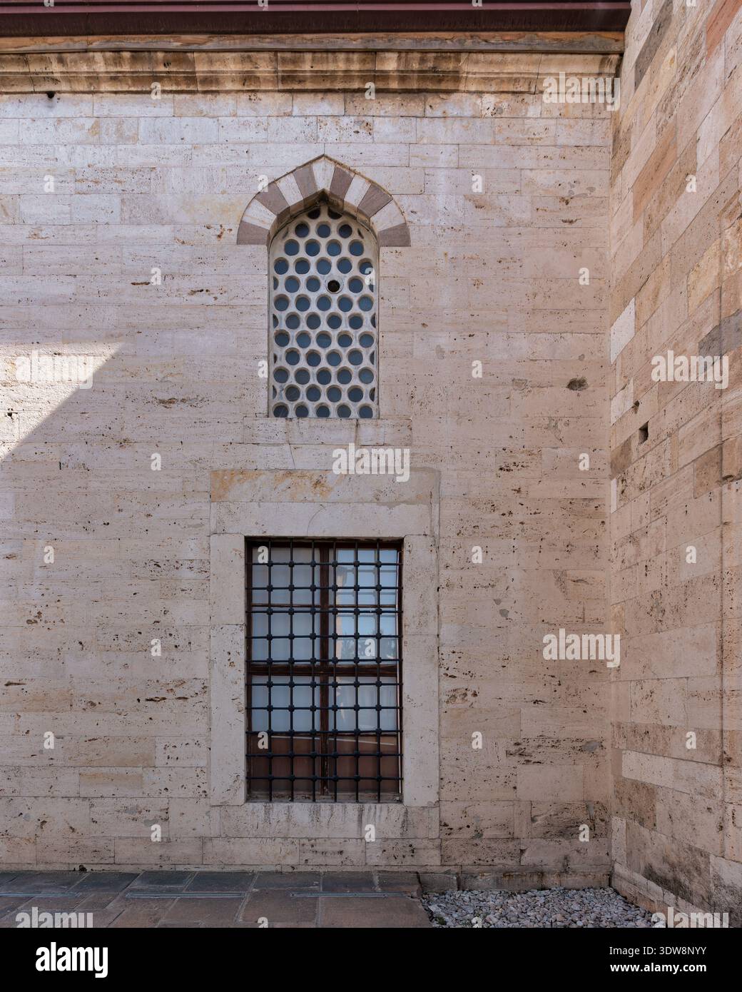 Dettagli esterni del Museo Mevlana: Parete in travertino con una finestra ad arco di pannelli circolari e una finestra rettangolare a sbarramento, Konya, Turchia Foto Stock