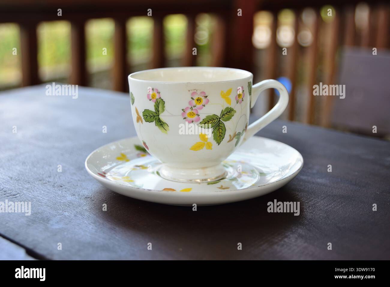 Primo piano di una tazza di caffè o tè su un tavolo di legno. Motivi intricati su pura porcellana bianca e venatura di legno trasparente creano una scena tranquilla Foto Stock
