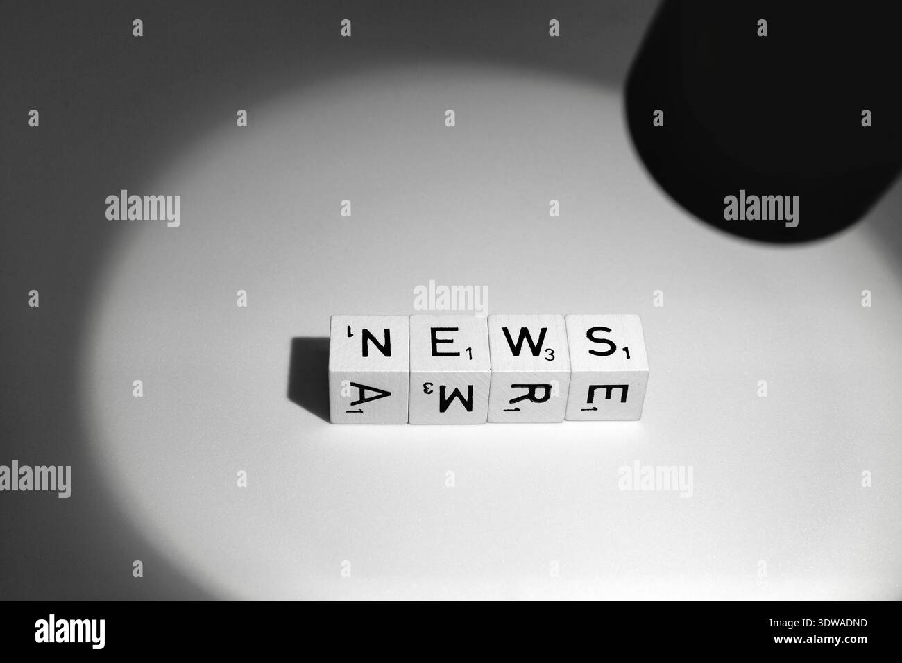 I cubi di lettere illuminati in fila formano il simbolo della parola notizie per notizie monocromatiche Foto Stock