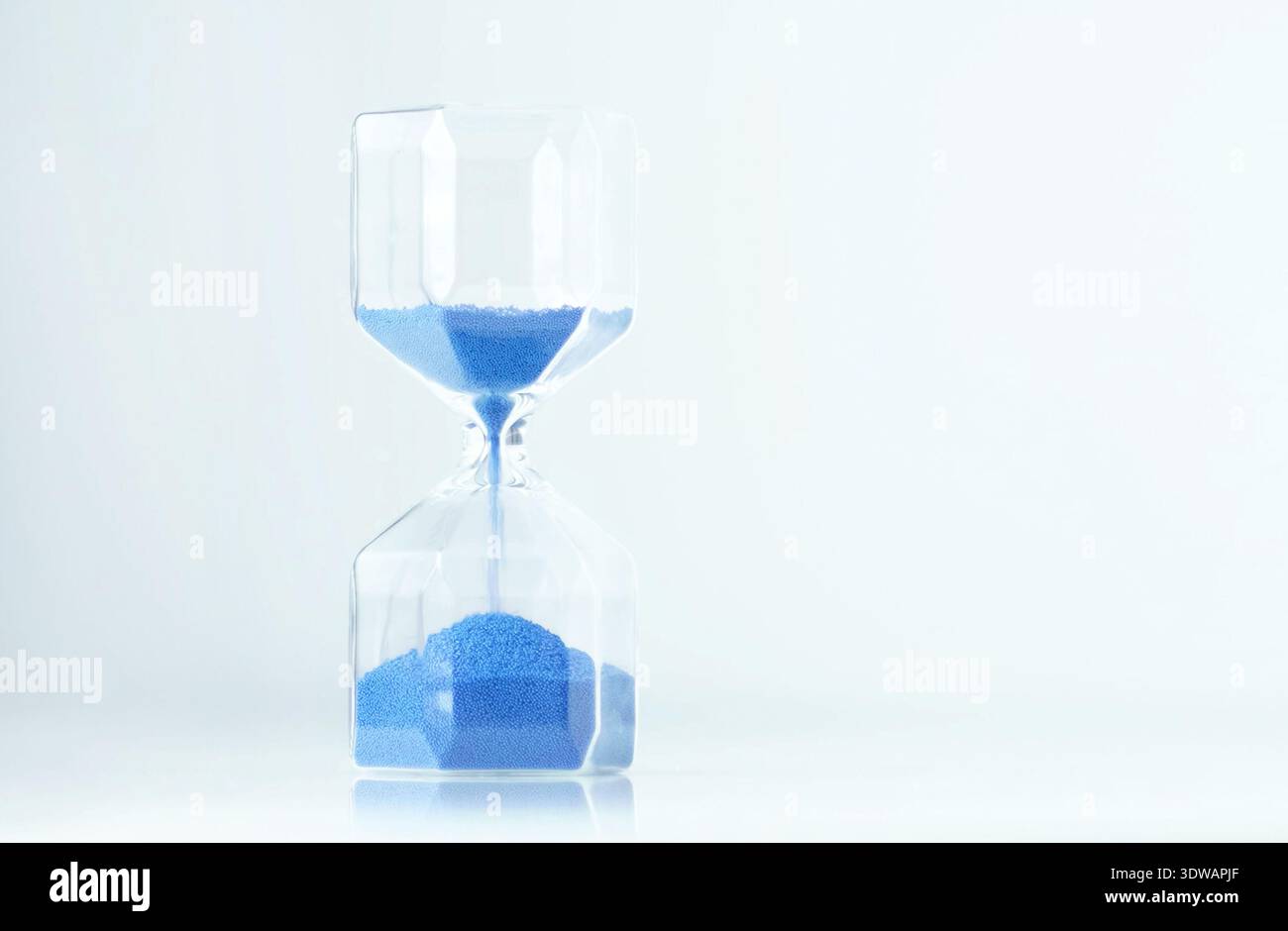 Clessidra con timer minimale con sabbia blu e spazio vuoto, estetica moderna e delicati riflessi. I momenti lenti possono ridurre l'ansia e. Foto Stock