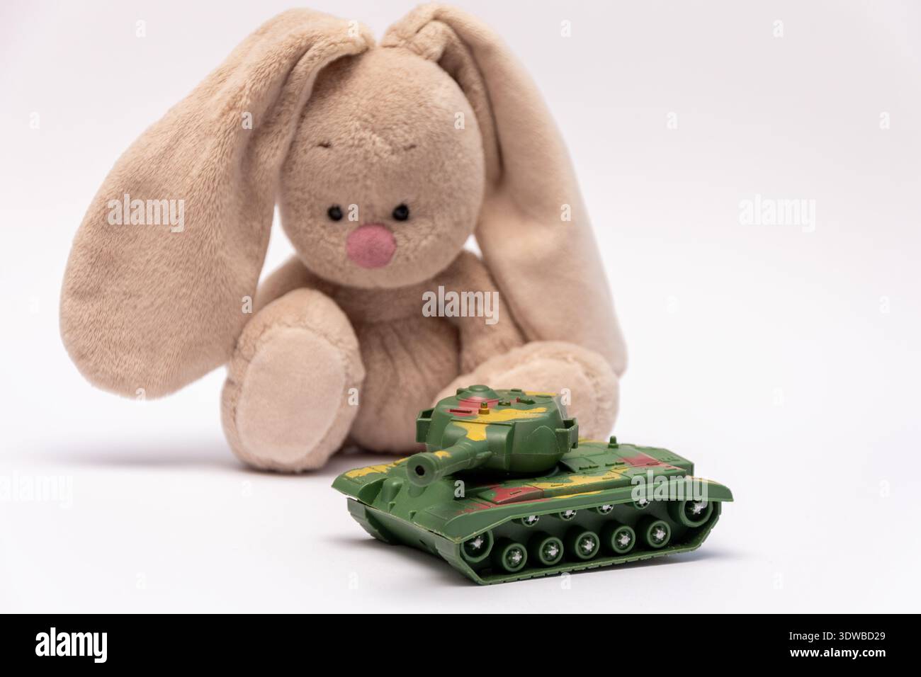 Contrasto tra l'infanzia e la guerra mostrato dal giocattolo militare e dal peluche. Foto Stock