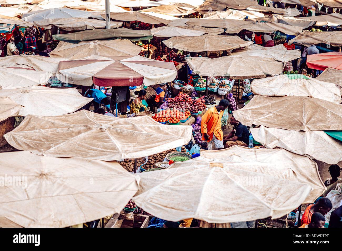 Kampala, Uganda - 28 marzo 2024: Vista di un vivace mercato sotto un mare di ombrelli, dove prodotti vivaci e abbigliamento colorato creano un vivace nastro Foto Stock