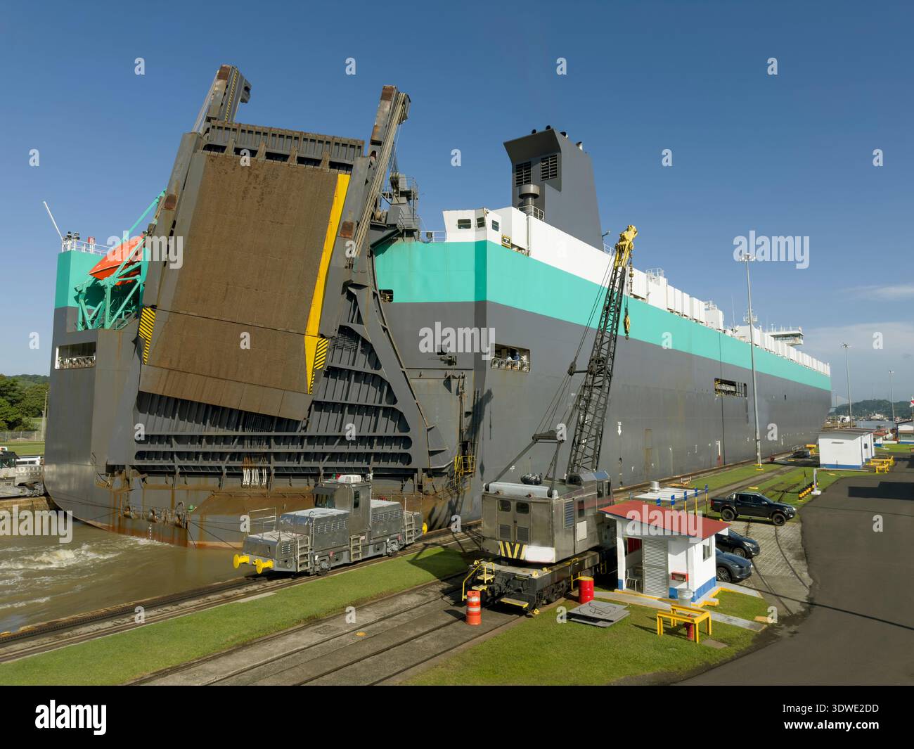 Una grande nave naviga sul Canale di Panama, mostrando la meraviglia ingegneristica e i vivaci dintorni. La scena cattura l'incredibile fusione del natur Foto Stock