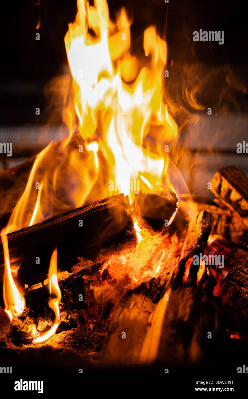 Un fuoco sereno lampeggia dolcemente, emettendo un caldo bagliore durante un ritiro di consapevolezza. Perfetto per meditazione e riflessione sotto un cielo stellato, offeri Foto Stock