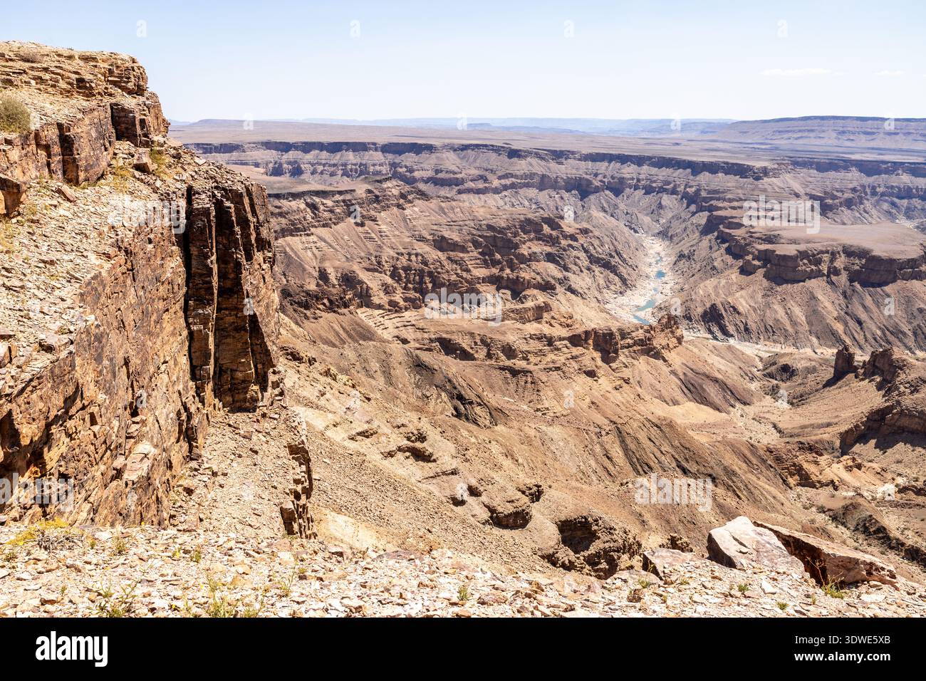 Splendida vista del Fish River Canyon in Namibia, caratterizzato da scogliere spettacolari e un vasto paesaggio desertico sotto un sole luminoso. Meta di viaggio popolare per Foto Stock
