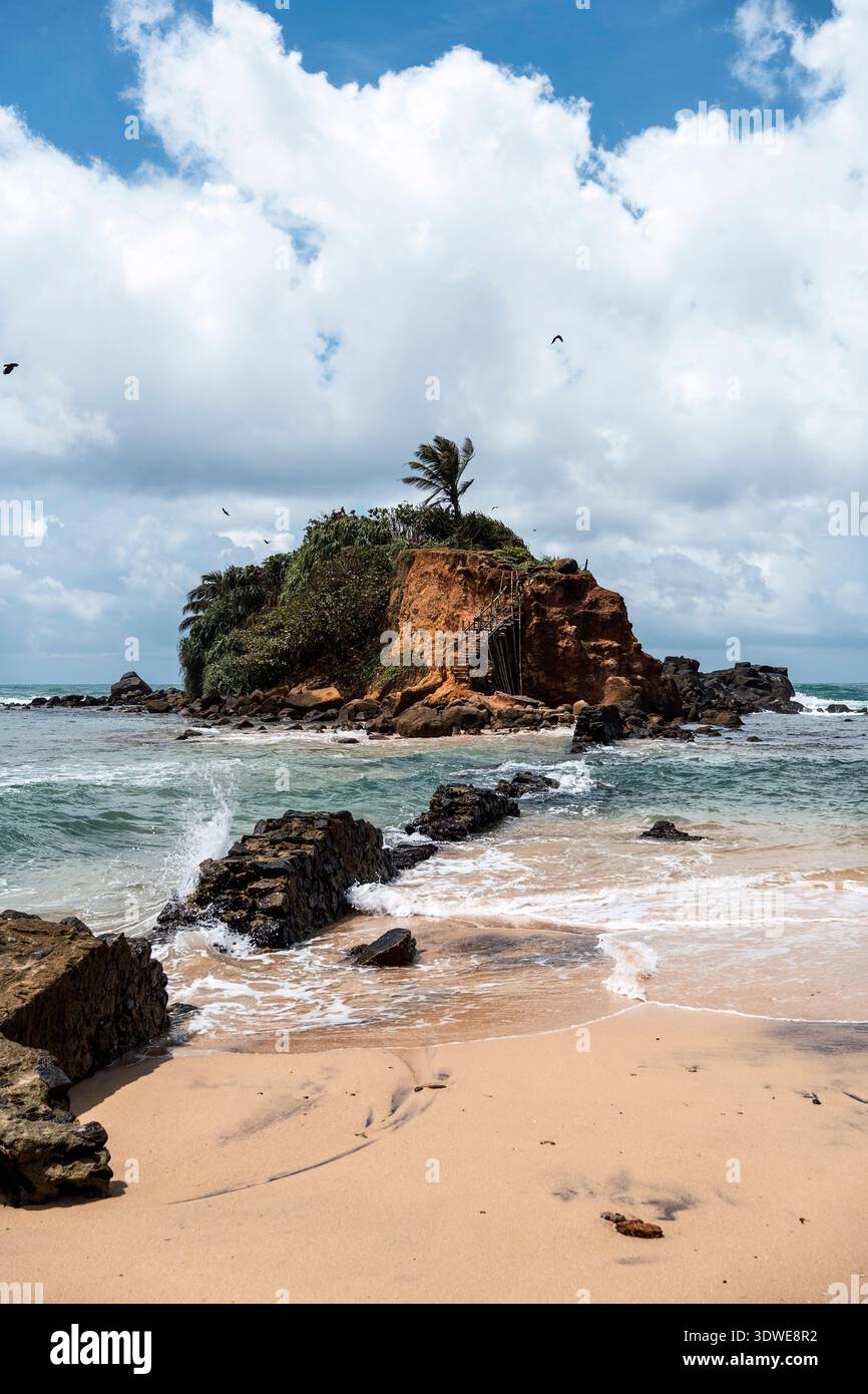 Parrot Rock a Mirissa Beach offre splendide vedute costiere con onde che si infrangono dolcemente contro la riva. L'affioramento roccioso è circondato da un Foto Stock