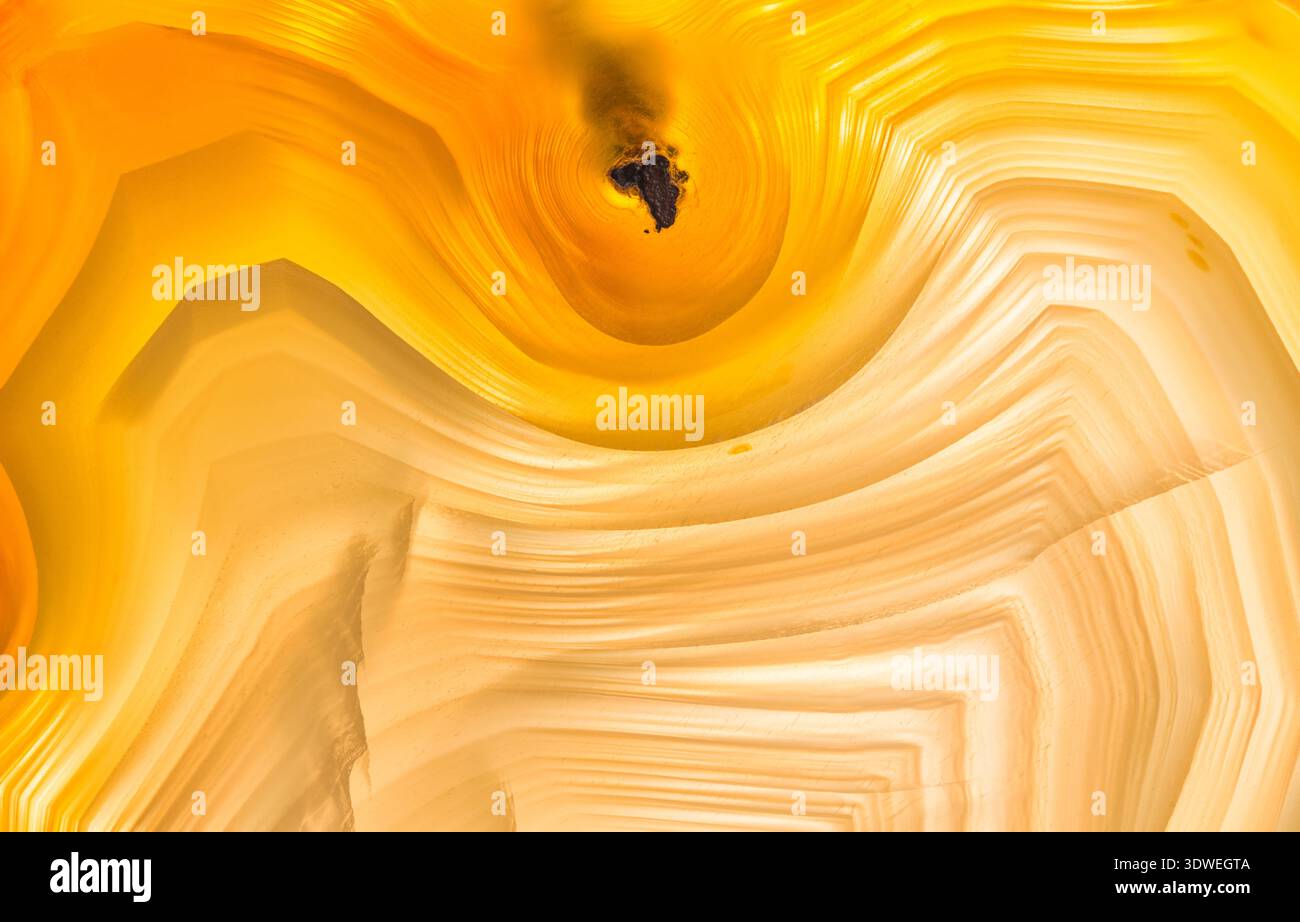 Macrofotografia dei pattern di banda in una fetta di agata brasiliana; pattern e colori sono migliorati dalla retroilluminazione; Agate è un From di criptocristallo Foto Stock