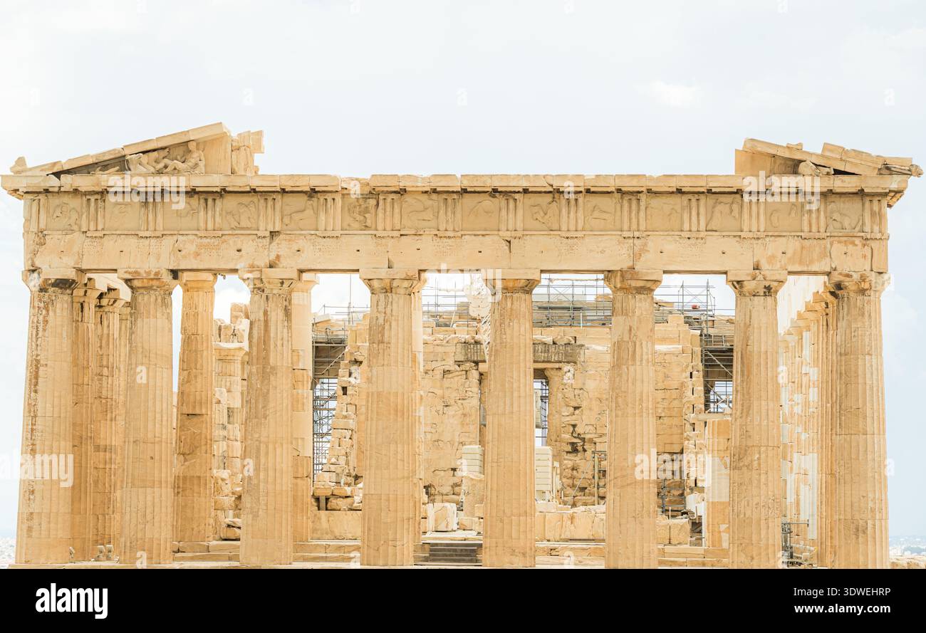 L'iconico tempio del Partenone sull'Acropoli di Atene, Grecia, si erge maestoso con le sue antiche colonne e i fregi dettagliati, adagiato su un blu chiaro Foto Stock