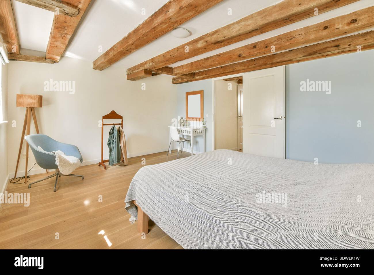 Una camera elegante con travi a soffitto in legno, comodi posti a sedere e arredi moderni. La combinazione di texture e colori crea un'atmosfera rilassante Foto Stock