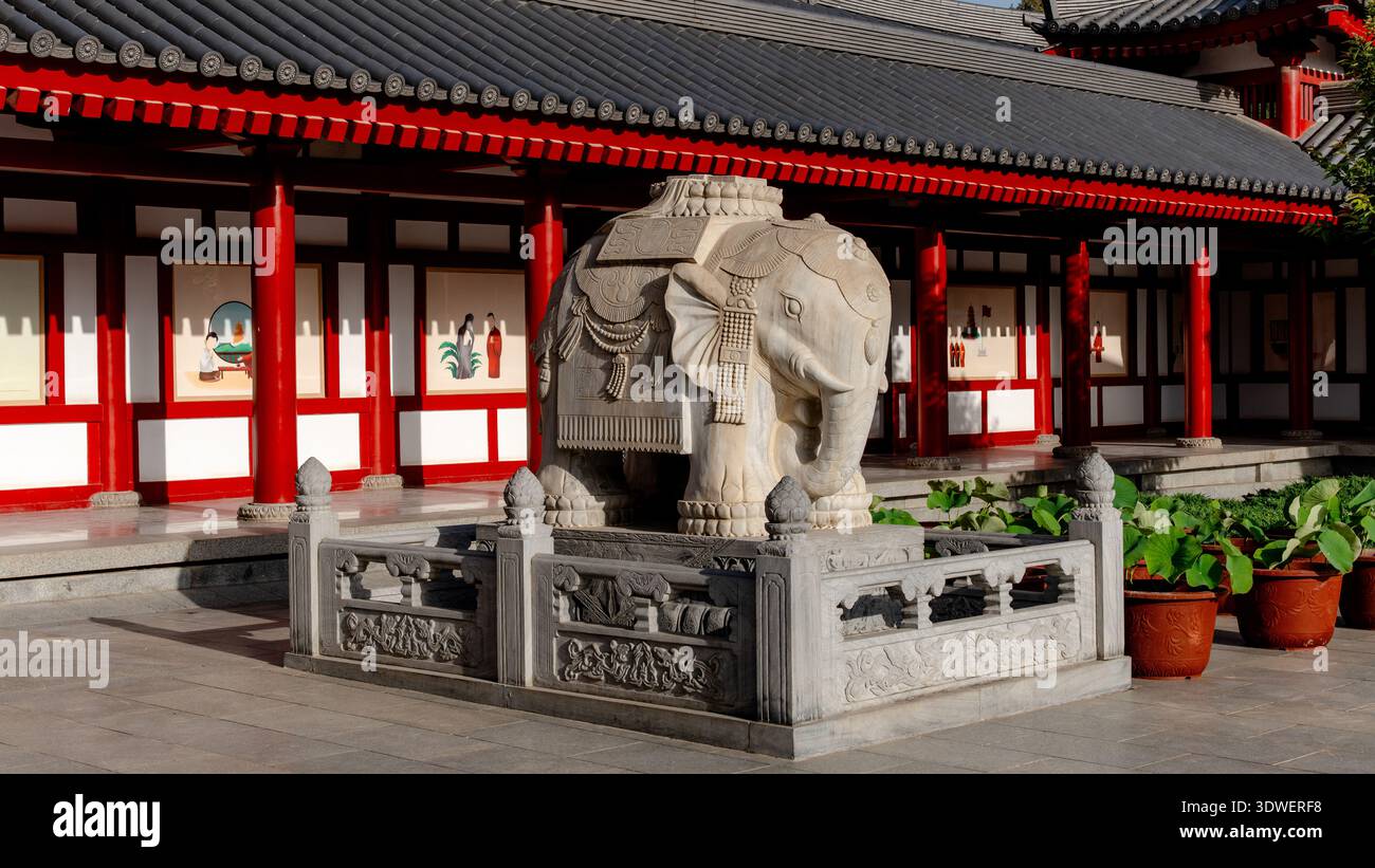 Una scultura di elefante in pietra splendidamente lavorata vicino alla Pagoda dell'Oca selvaggia Gigante a Xian, Cina, circondata dalla tradizionale architettura rossa e bianca Foto Stock