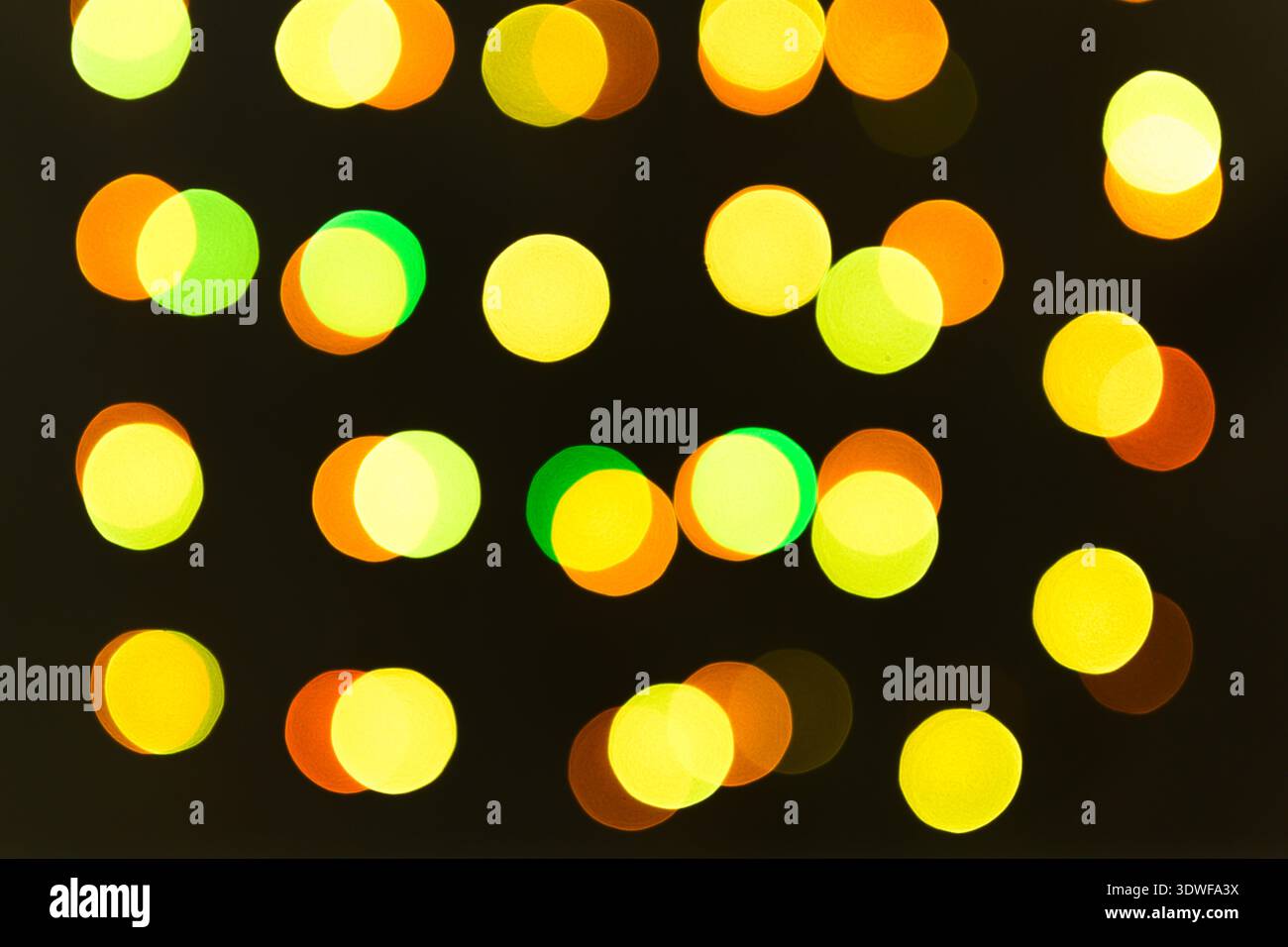 Luci sfocate di una ghirlanda di colori caldi. Texture natalizie per decorazioni e design grafico. Foto Stock