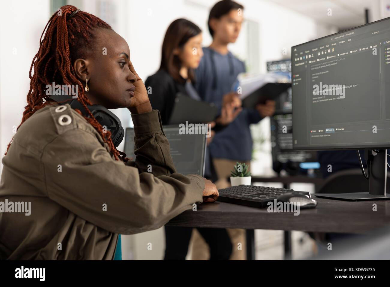 Lo sviluppatore femminile prende il momento di riflettere durante il debug del codice software sul computer. Il programmatore mostra segni di pressione e concentrazione, lavorando per risolvere i problemi e completare il sito Web funzionale. Foto Stock