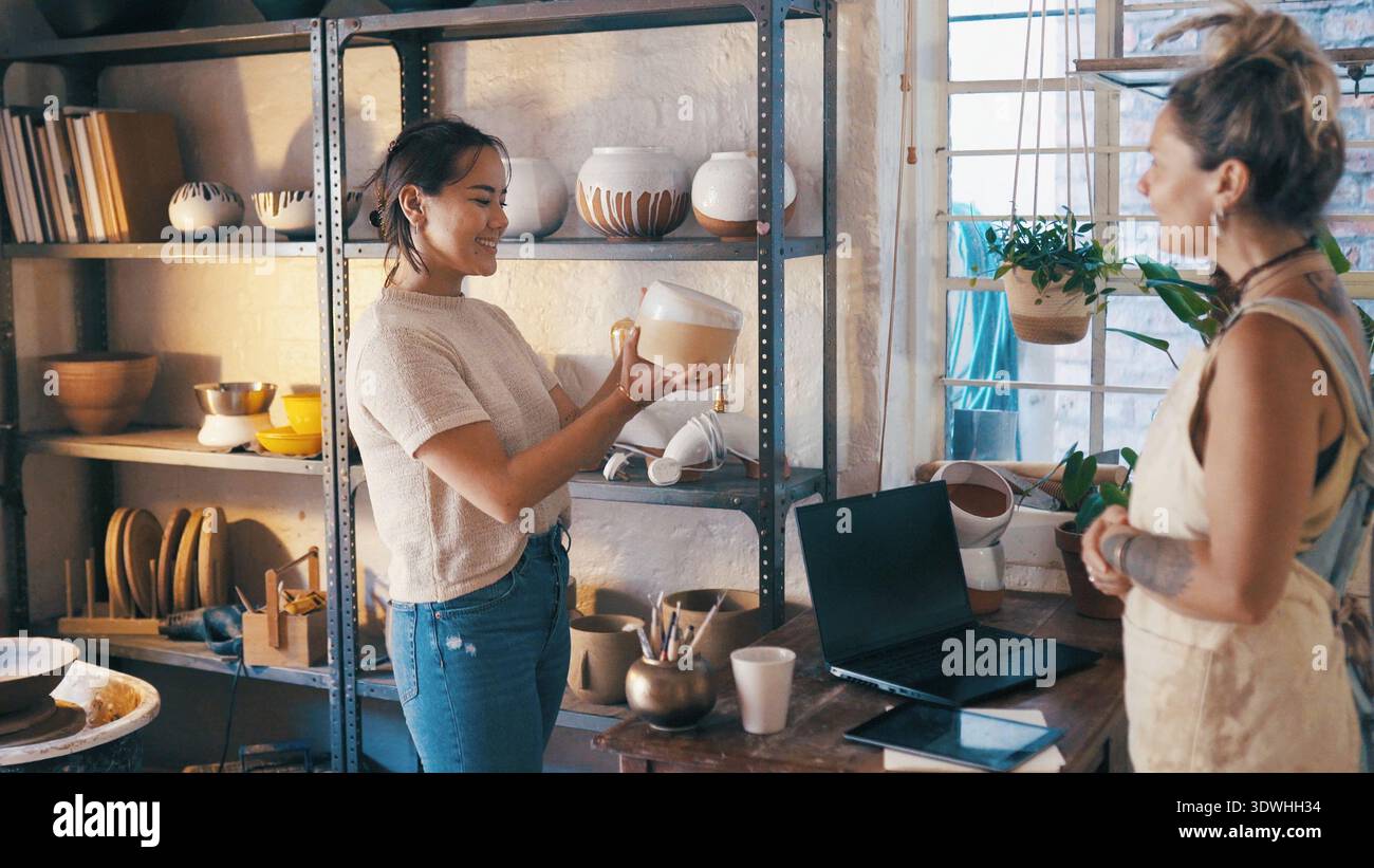 Servizio clienti, shopping e donne con ceramiche per decisioni, controlli di qualità o acquisti. Personale, negozio di ceramiche e proprietario con cliente in vendita Foto Stock