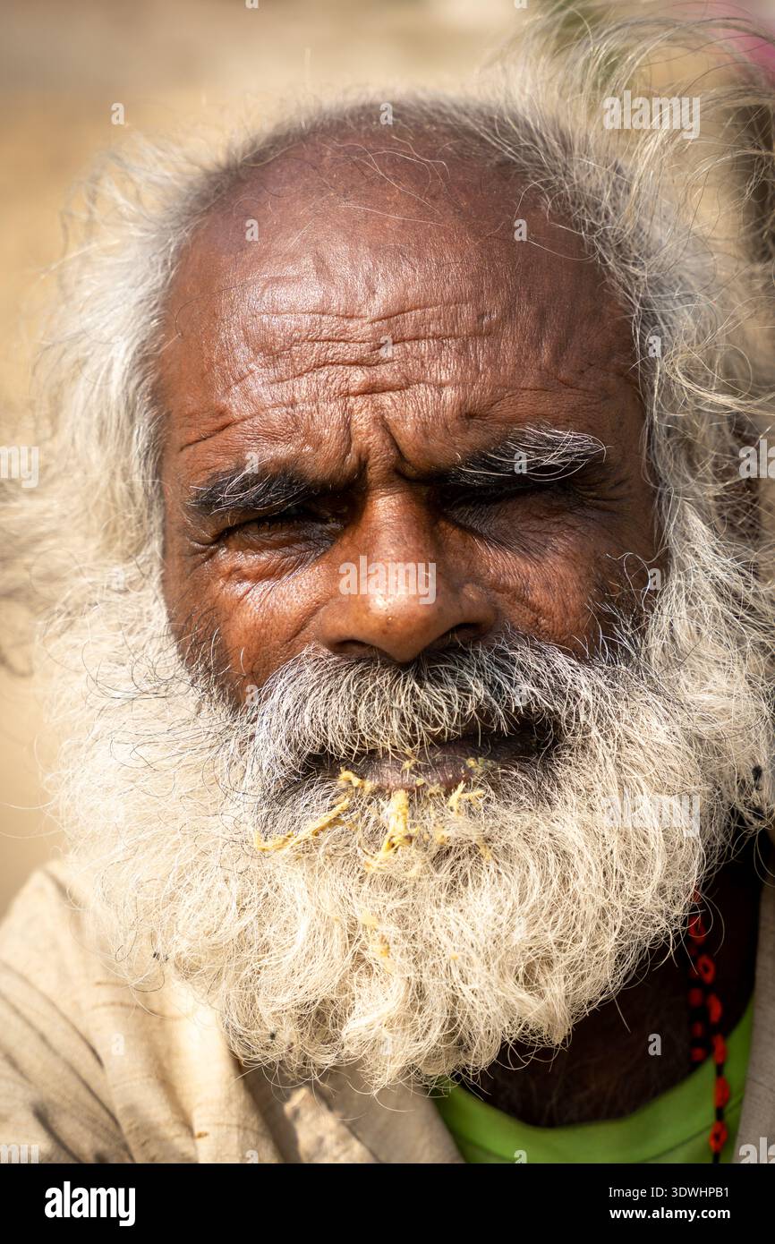Ritratto ravvicinato di un uomo anziano che si lava i denti a Varanasi, in India, mostrando dettagli del viso e barba. Foto Stock