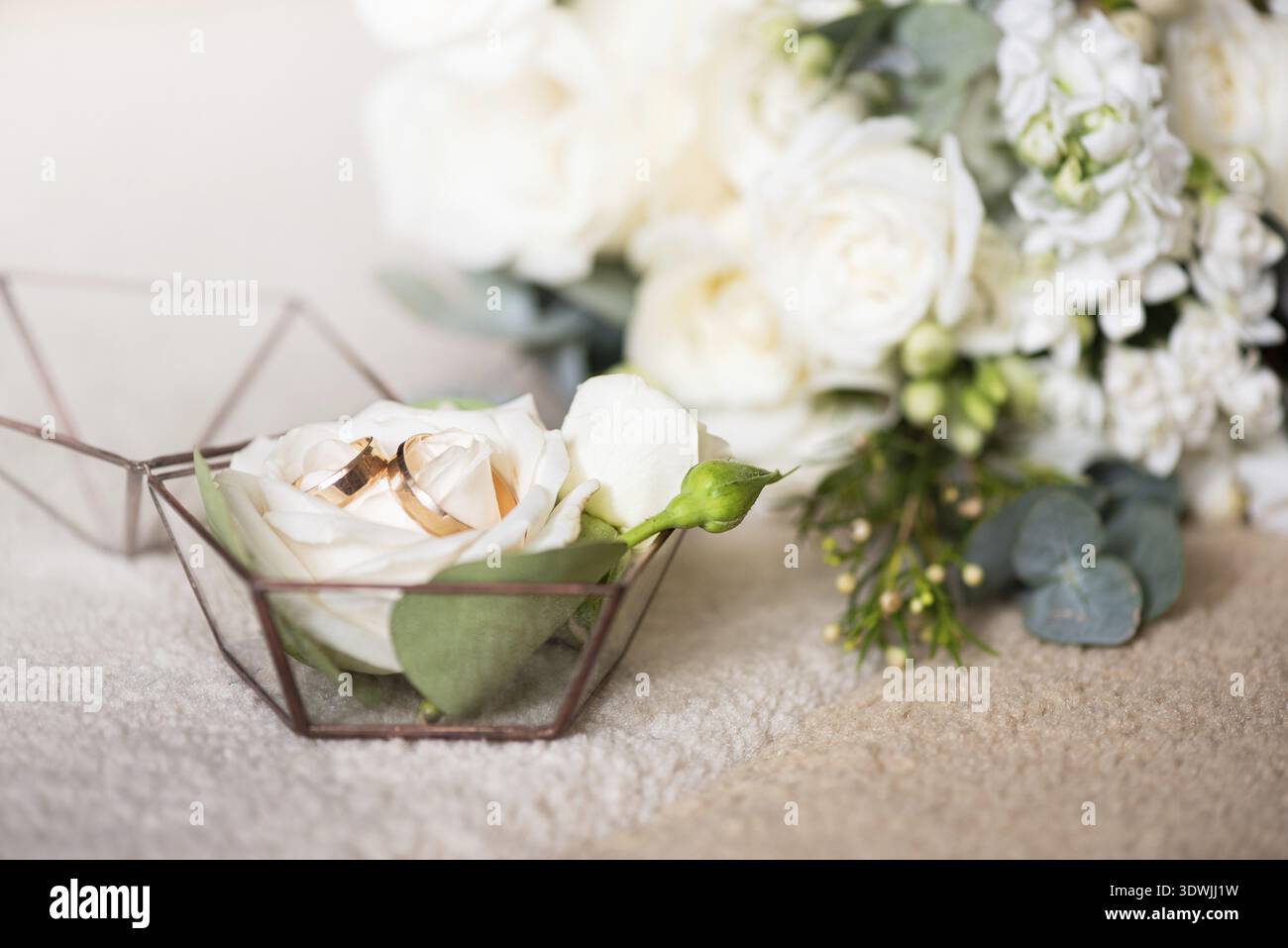Due fedi nuziali in una bella scatola e un bouquet di fiori. Temi di fidanzamento, dichiarazione d'amore, giorno delle nozze, servizi di fiorista Foto Stock