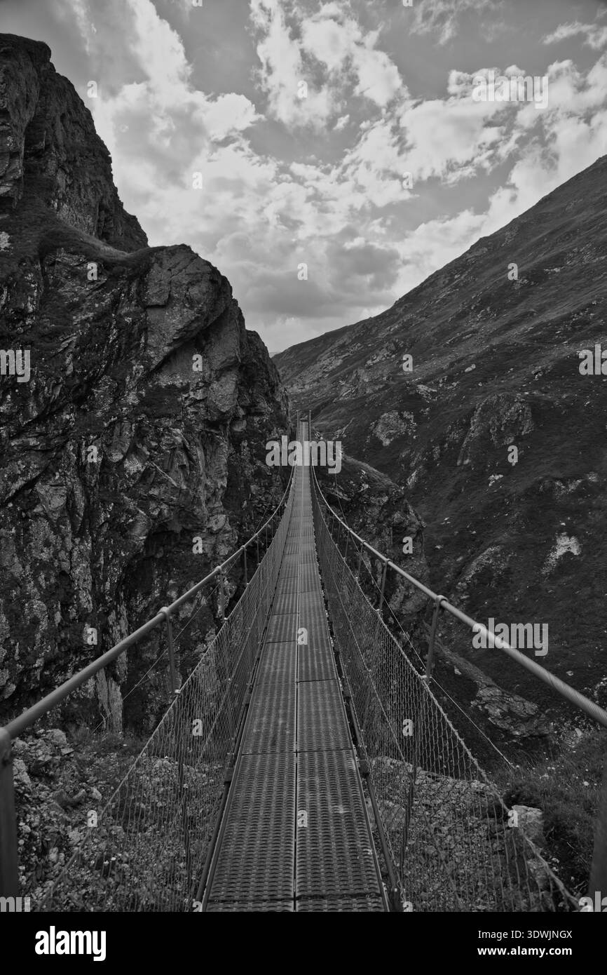 Uno splendido ponte sospeso a Greina, in Svizzera, che mostra spettacolari paesaggi montani. Foto Stock