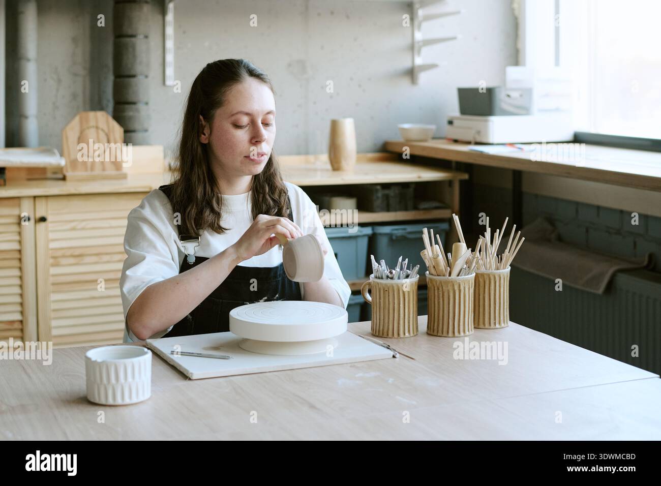 Giovane donna che dà forma alla ceramica nel Modern Art Studio Foto Stock