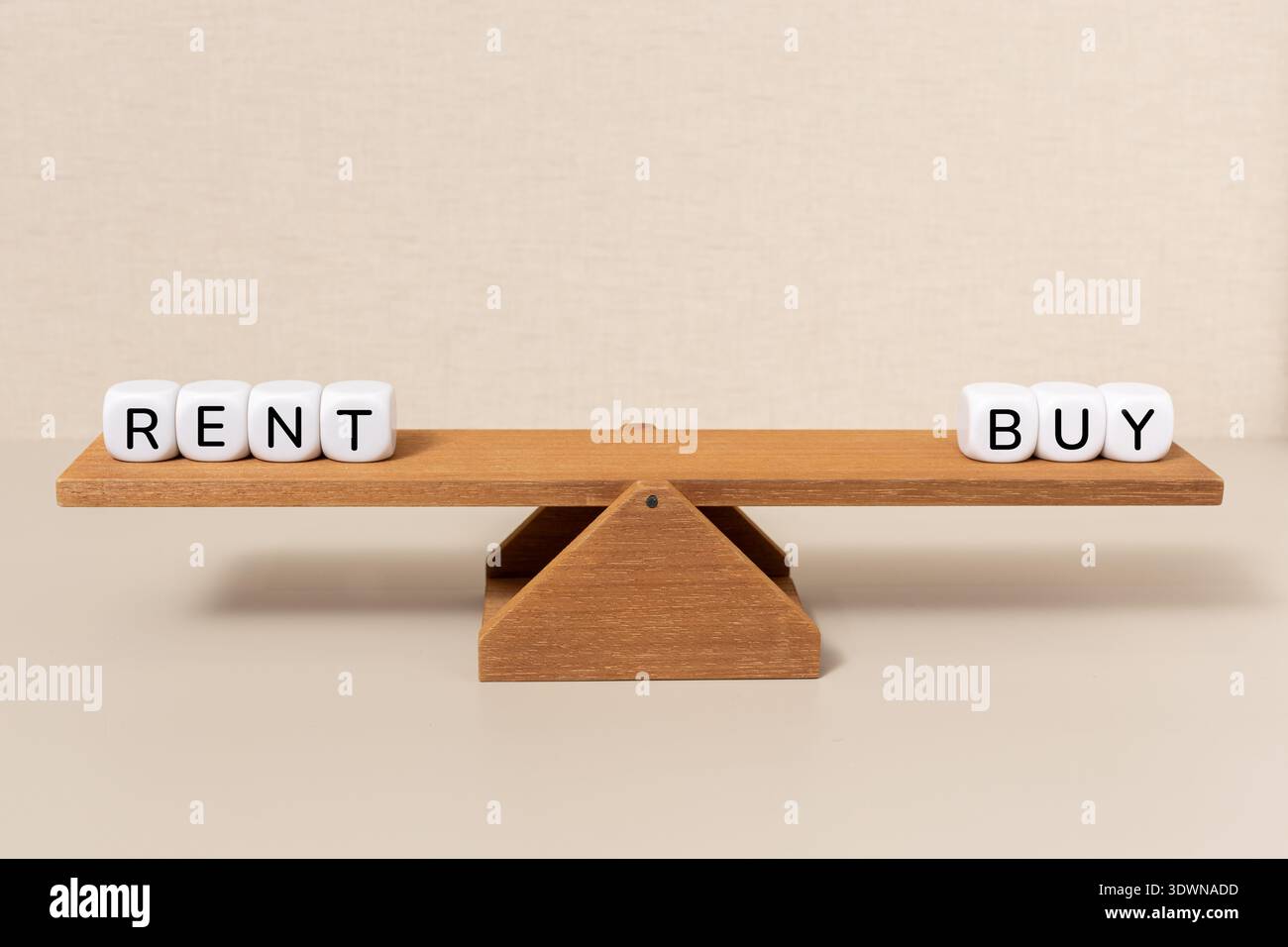Il bilanciamento tra affitto e acquisto su una falda di legno Foto Stock