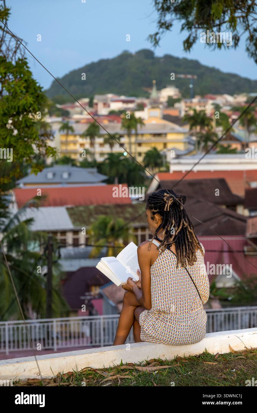 Francia, Guyana francese, Cayenne, Fort Cépérou, donna che legge un libro alla fine della giornata per godersi il panorama Foto Stock