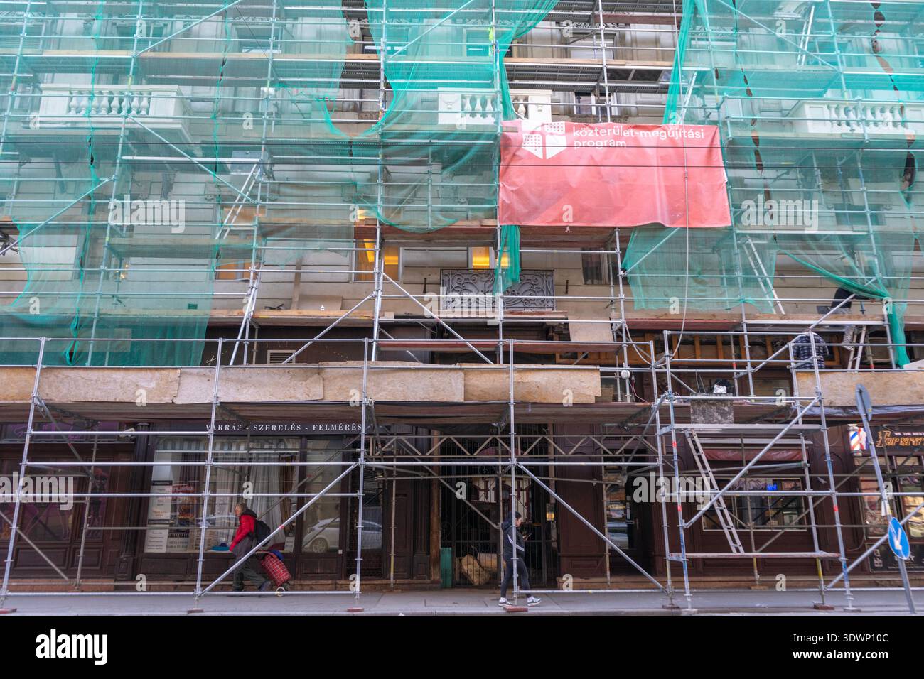 Ponteggi e reti verdi su 1068 Budapest, via Király 70 — edificio citato nei resoconti dei media collegati ai fascicoli di Jeffrey Epstein. Foto Stock