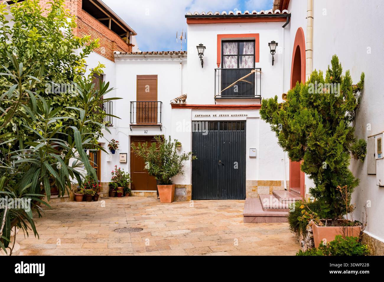 Piccola piazza con vasi di fiori e alberi ombreggiati. Yunquera, Málaga, Andalucía, Spagna, Europa Foto Stock