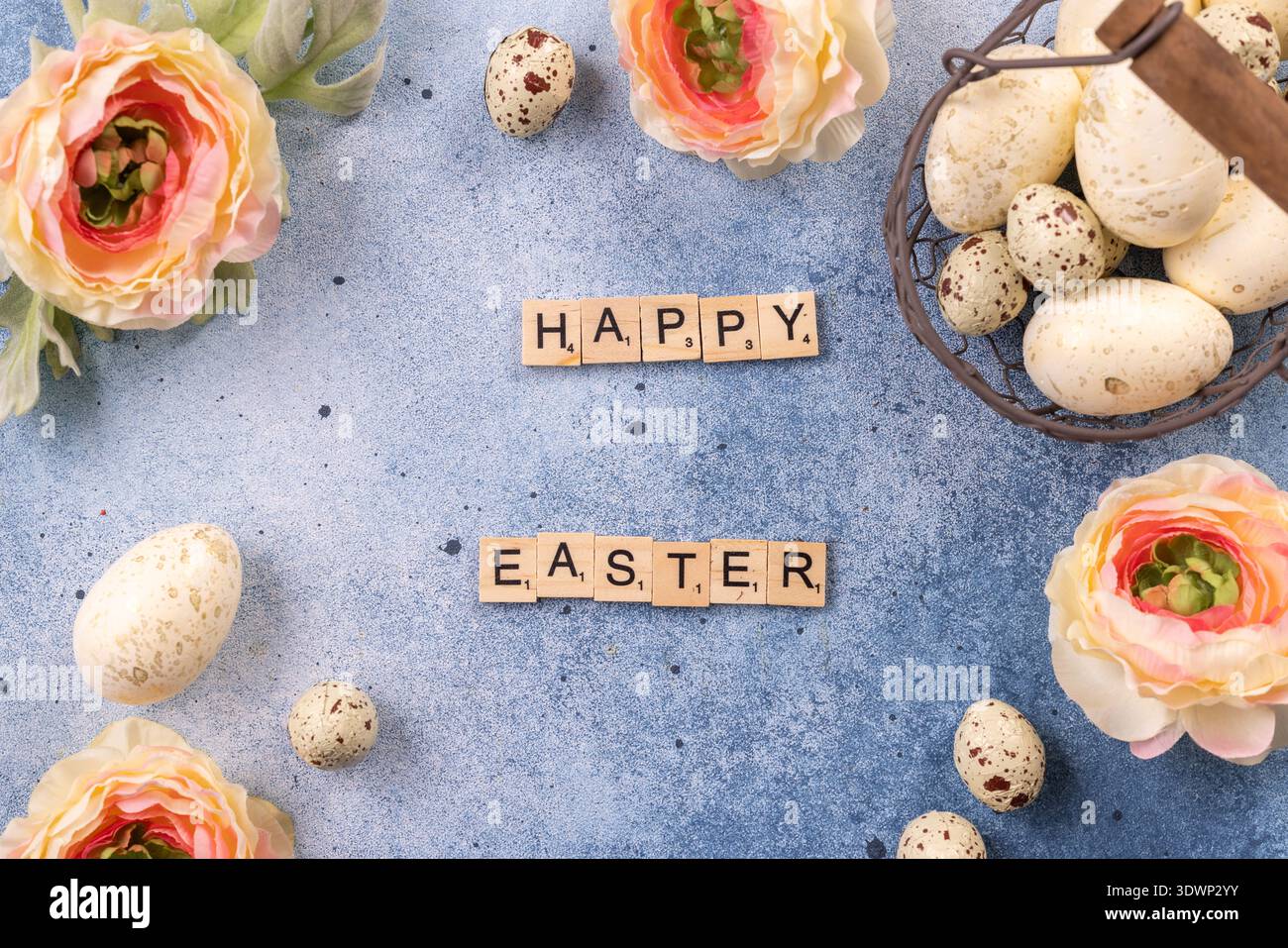 Lettere di scrittura che scrivono buona pasqua su sfondo blu, con uova decorative e delicati fiori primaverili che creano un appartamento festoso Foto Stock