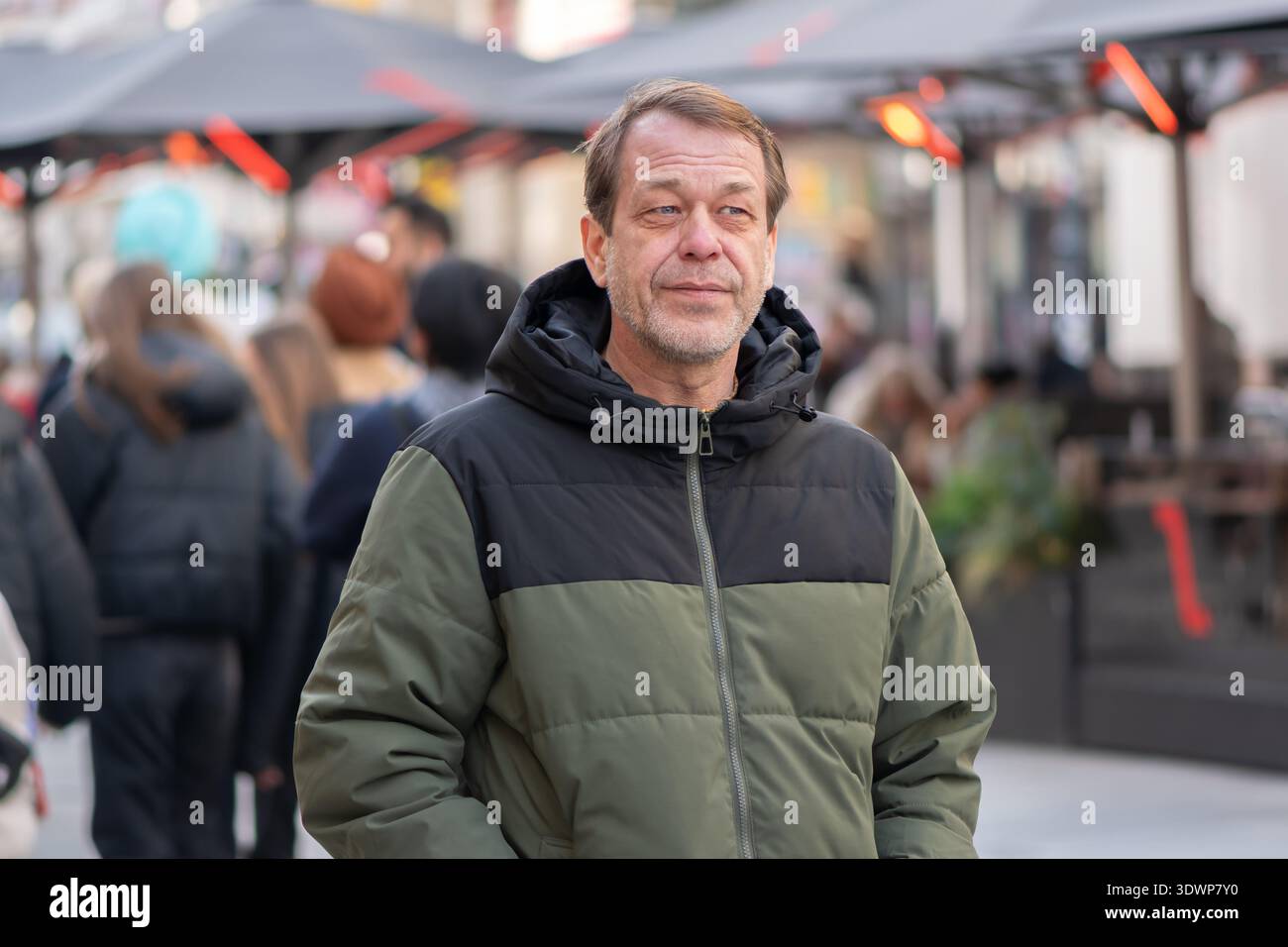 Uomo di 55 anni che cammina lungo la strada della città europea nel centro della città. Foto Stock