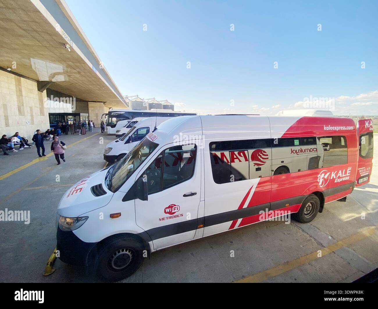 Istanbul, Turchia - 20 ottobre 2025: Autobus turco con marchio Kale parcheggiato in una stazione, passeggeri seduti nelle vicinanze e struttura moderna Foto Stock