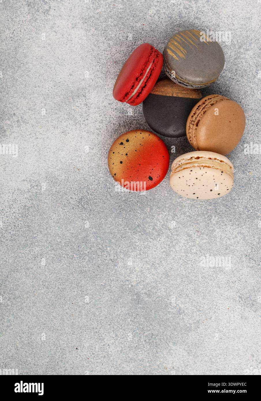 Biscotti assortiti di macaroon multicolore su sfondo grigio in cemento. Dolci macaron francesi. Deserto per buongustai. Messa a fuoco selettiva, t Foto Stock