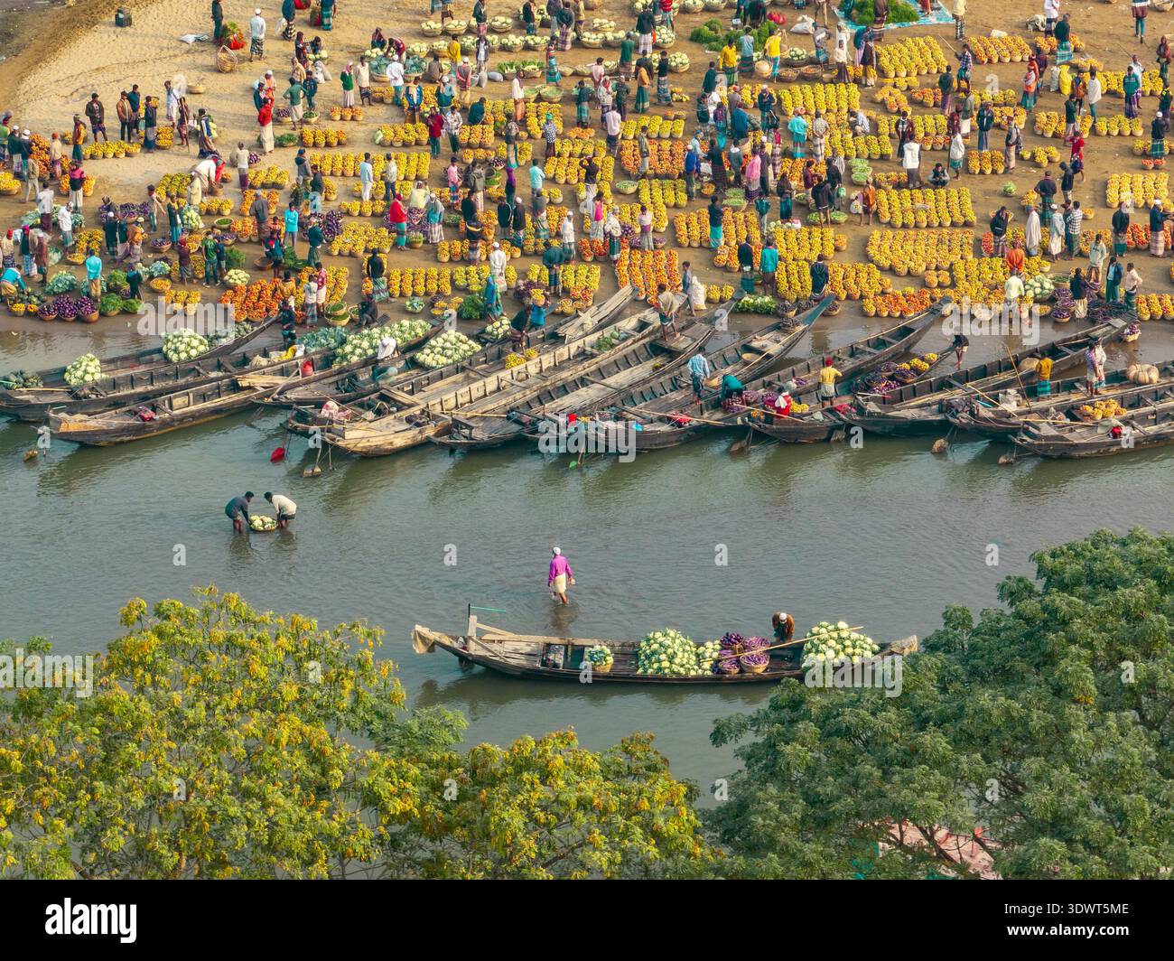 Sylhet, Bangladesh - 21 febbraio 2026: Vista aerea delle barche cariche di merci che costeggiano il fiume Surma, contrastando il vivace mercato Foto Stock