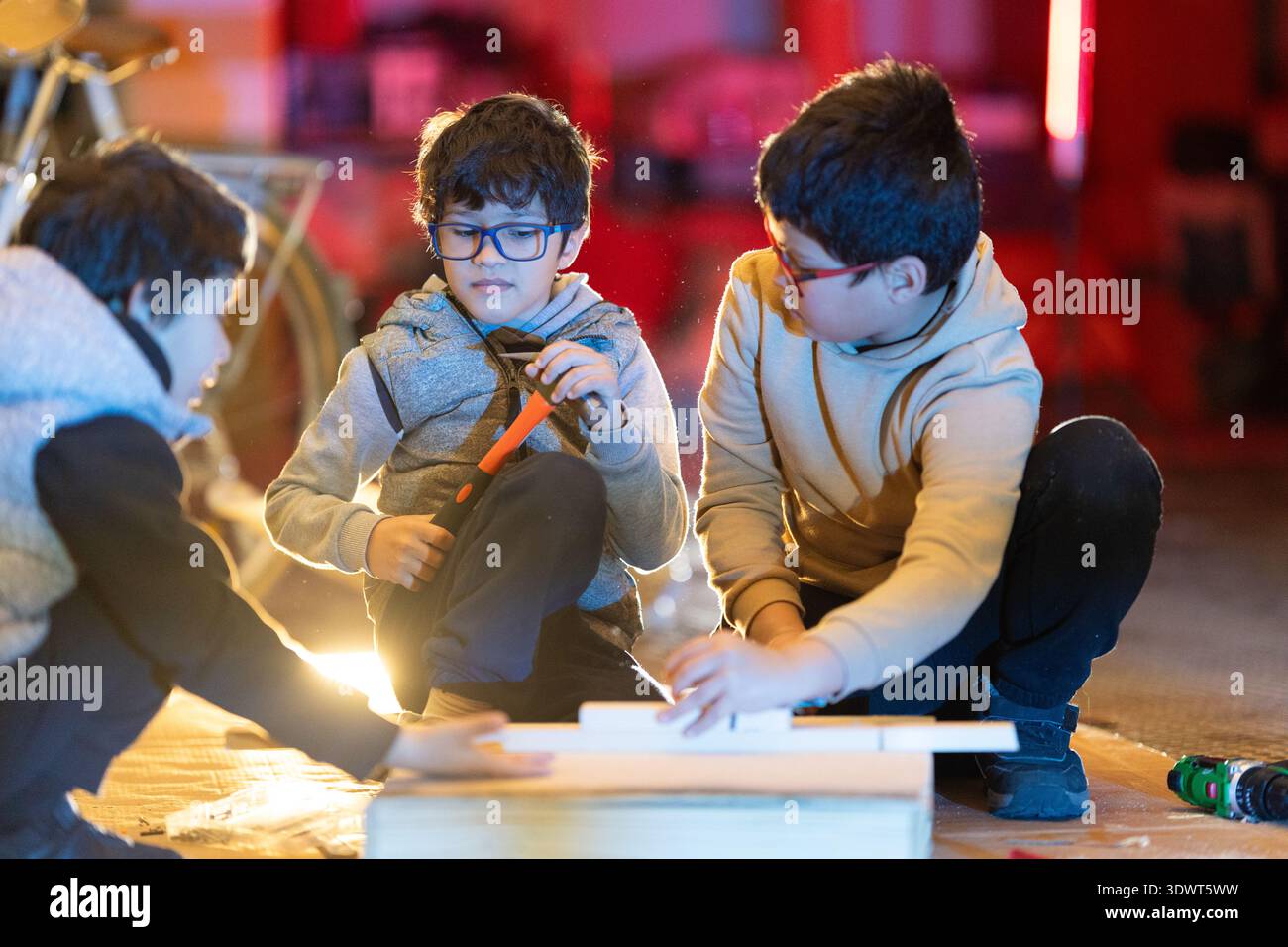 I bambini imparano in modo pratico le abilità di falegnameria in officina Foto Stock