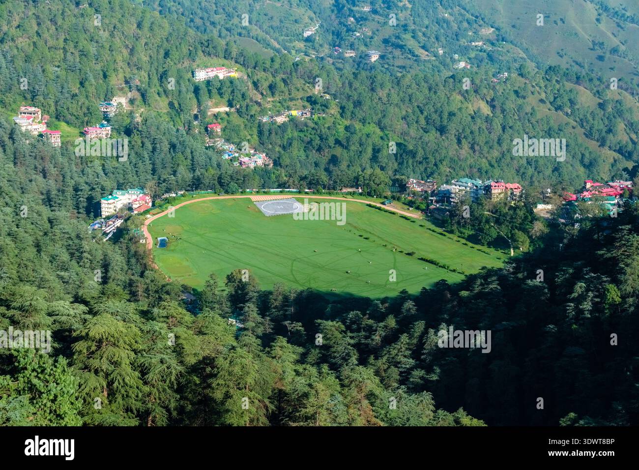Il campo da golf Naldehra è circondato da fitte foreste e da edifici residenziali sparsi a Shimla, con colline nebbiose in lontananza. Foto Stock