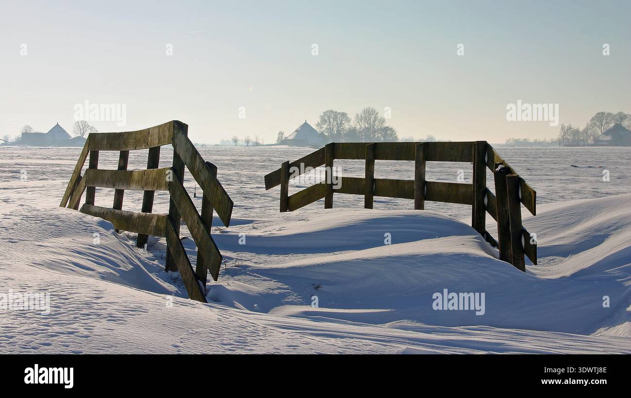 Recinzione in legno in un paesaggio invernale innevato in Europa Foto Stock