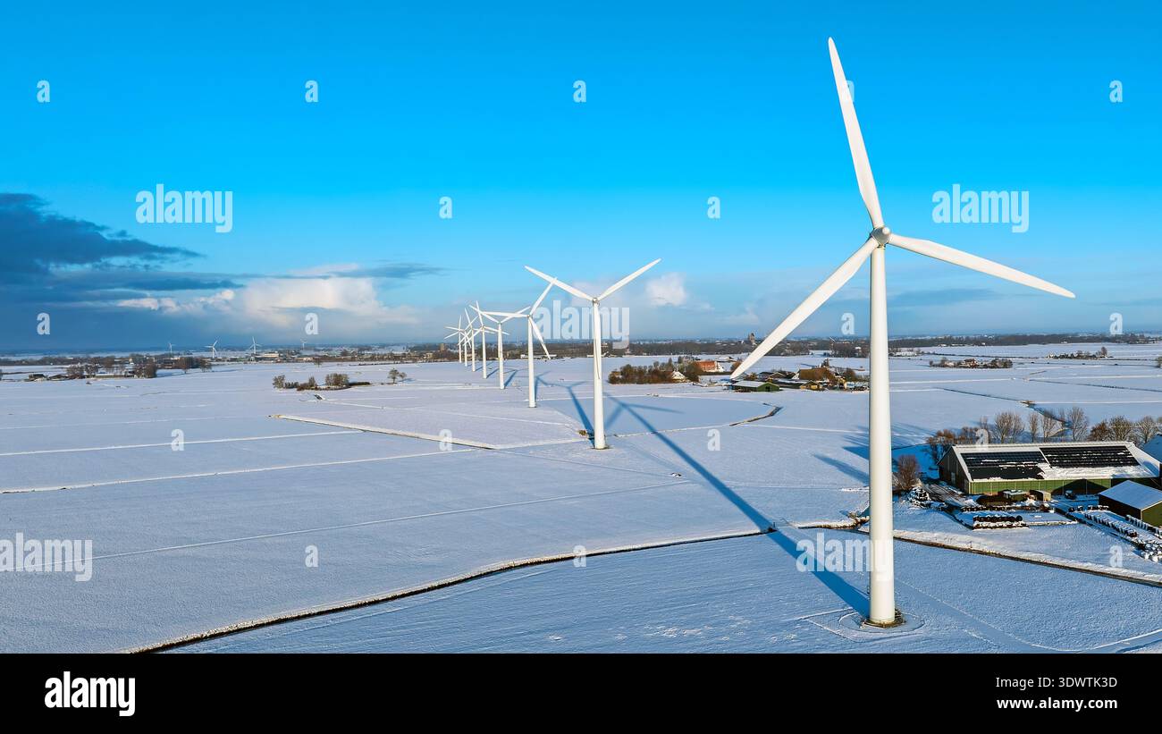 Turbine eoliche in un paesaggio rurale innevato Foto Stock