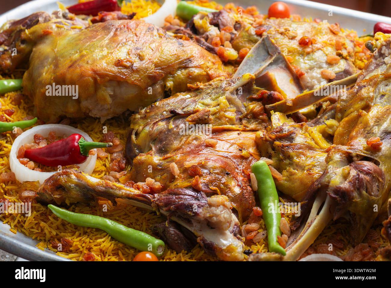 Ampio piatto di riso mandi tradizionale mediorientale condito con carne di agnello arrosto lento e peperoncino Foto Stock