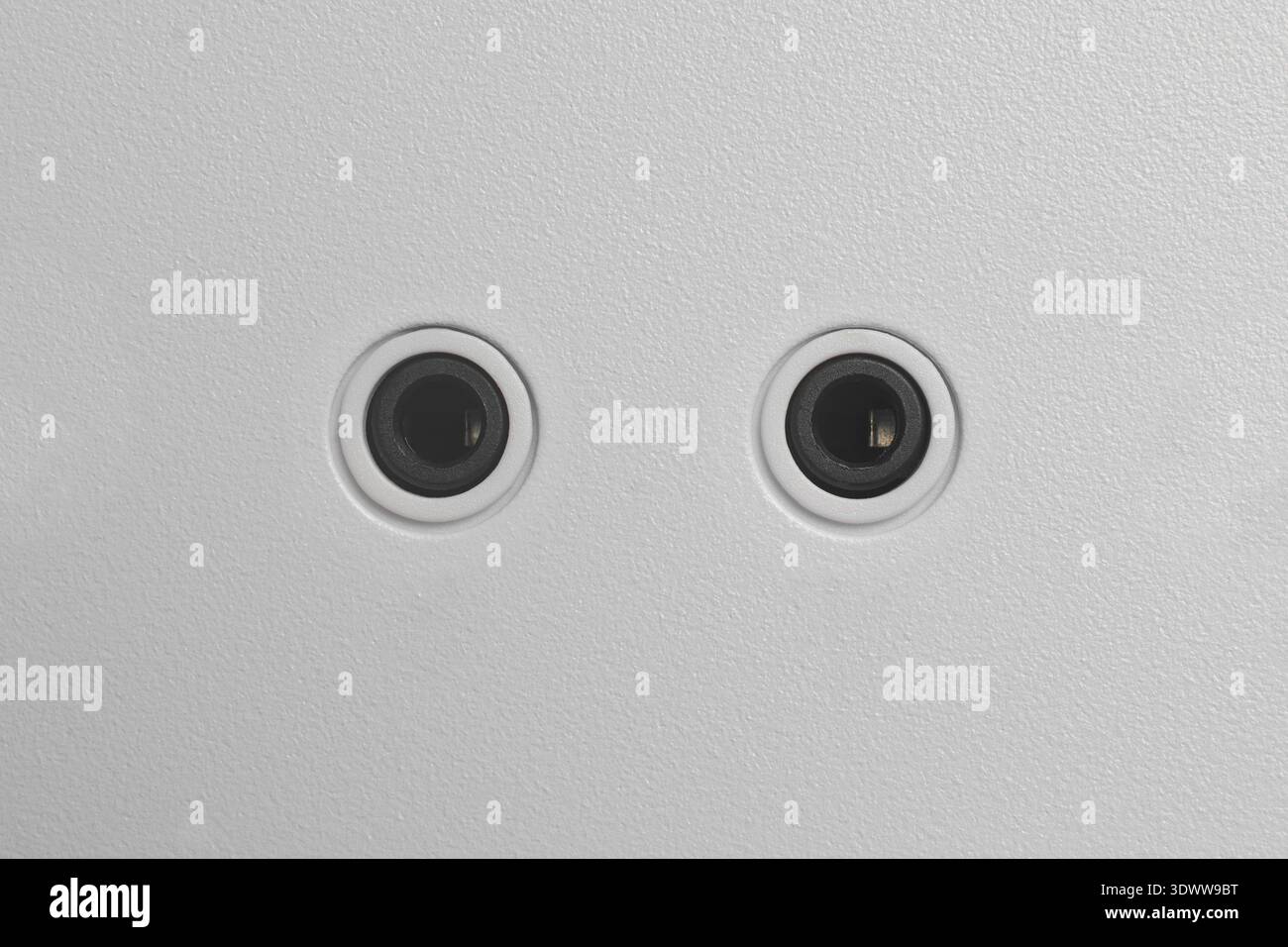 porte audio circolari nere da 3,5 mm con rivestimento in pc bianco testurizzato, connettori jack elettronici minimalisti, vista dall'alto con spazio di copia Foto Stock