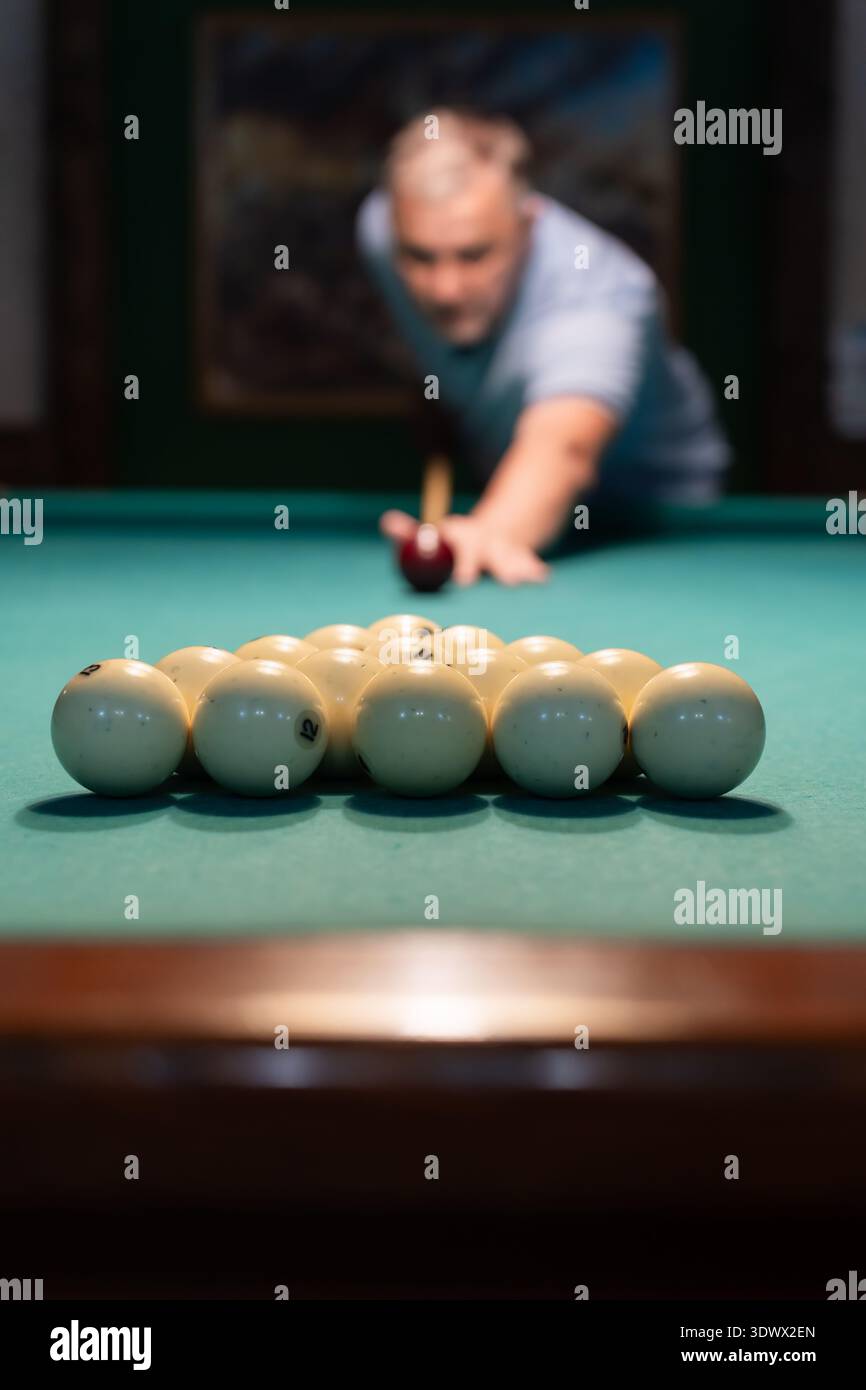 Giocatore mirato che collega Un colpo chiave per iniziare il gioco dello snooker. Foto Stock
