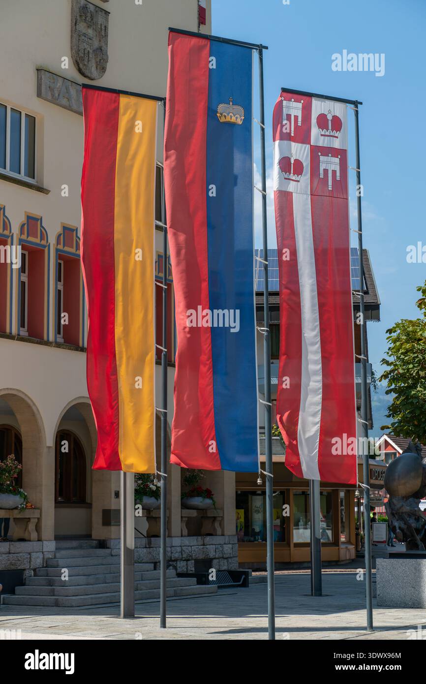 Tre bandiere esposte a Vaduz: La bandiera nazionale del Liechtenstein con corona, la bandiera storica giallo-rossa della dinastia principesca von und zu Lie Foto Stock