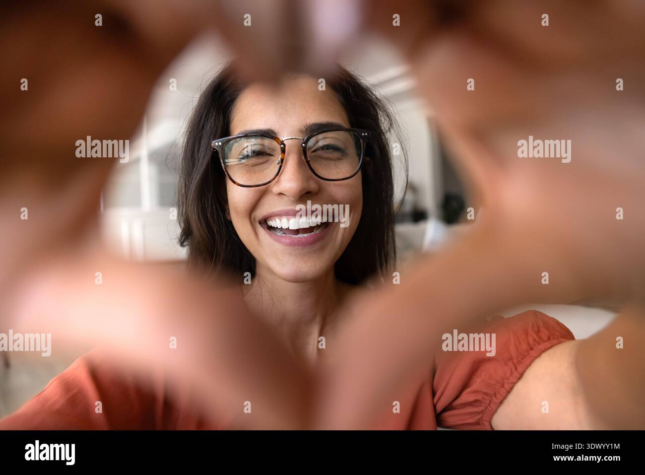 Donna brasiliana che fa forma al cuore con le mani, primo piano Foto Stock